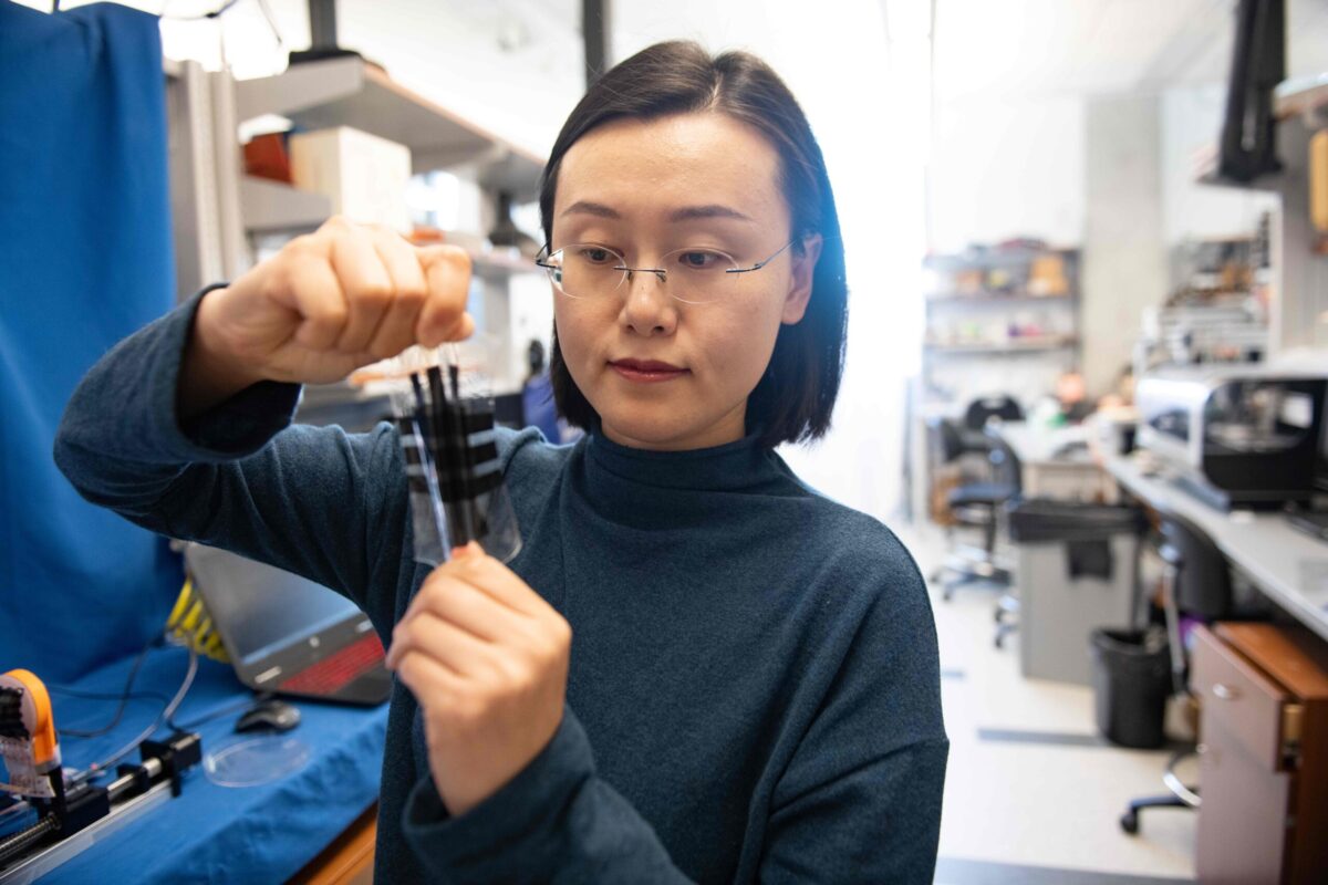 A researcher holds a piece of stretchable e-skin developed at The University of Texas at Austin.
