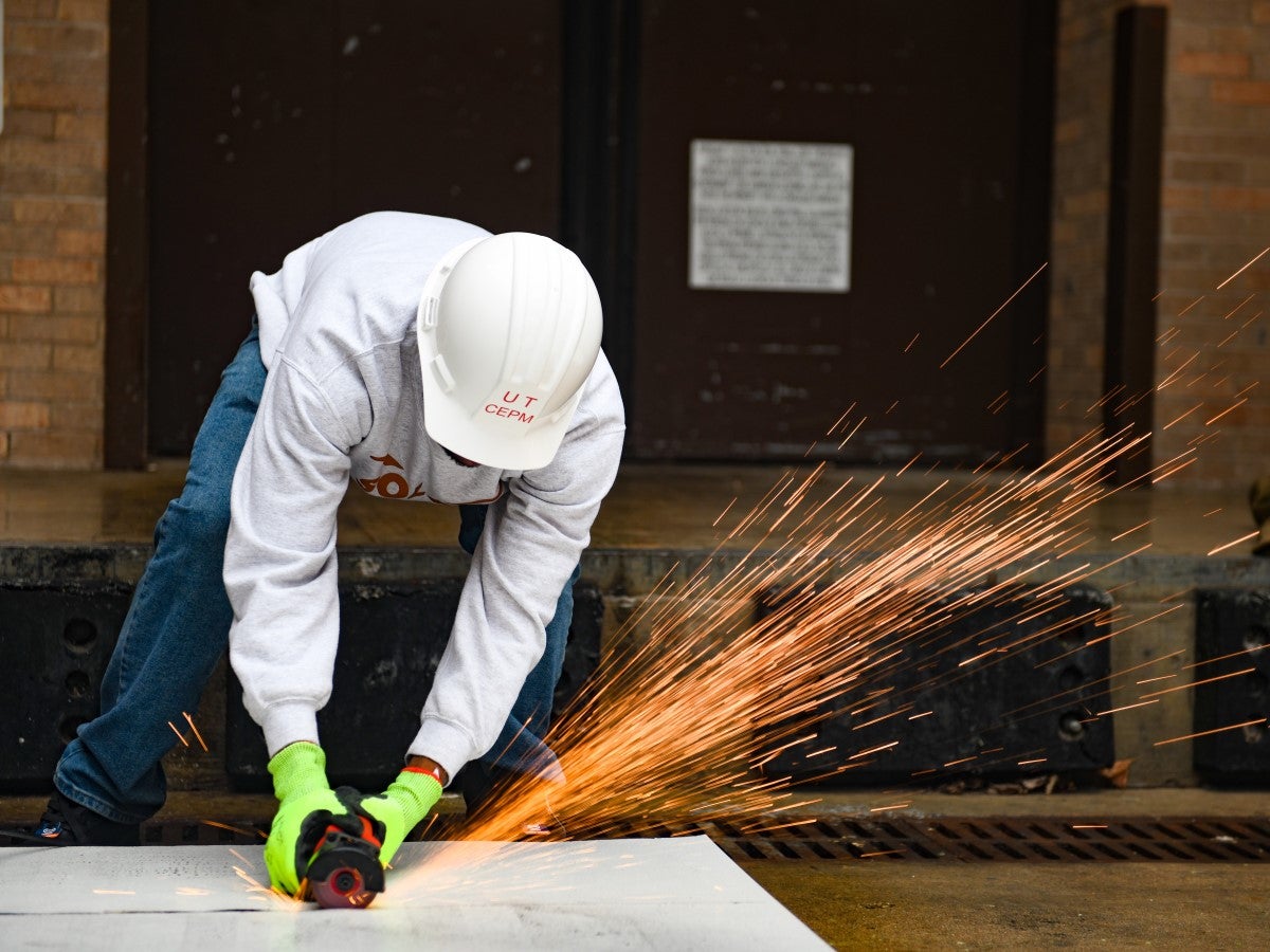 A person is cutting a metal panel