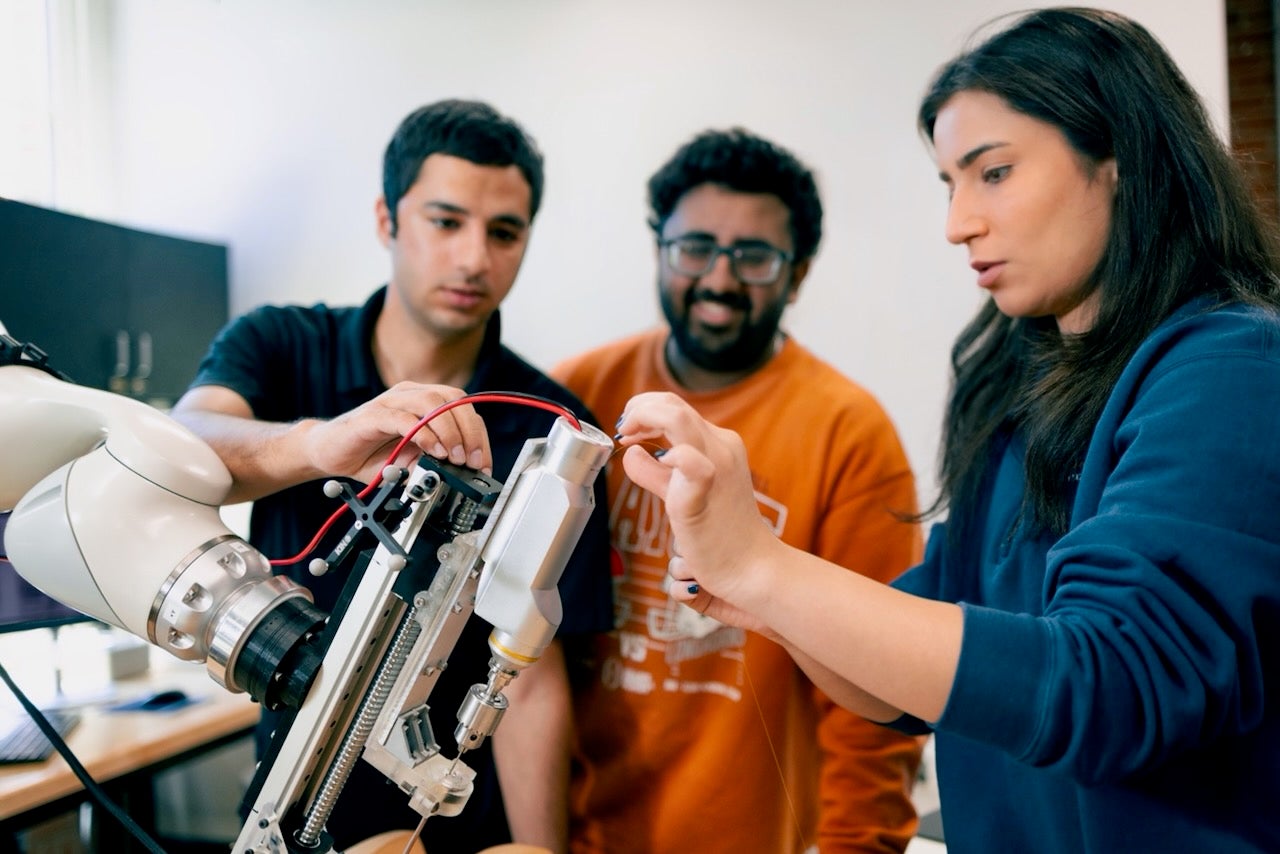 Researchers in Dr. Farshid Alambeigi’s lab adjust a robotic tool that helps surgeons perform incredibly complex procedures around the spine and pelvis.