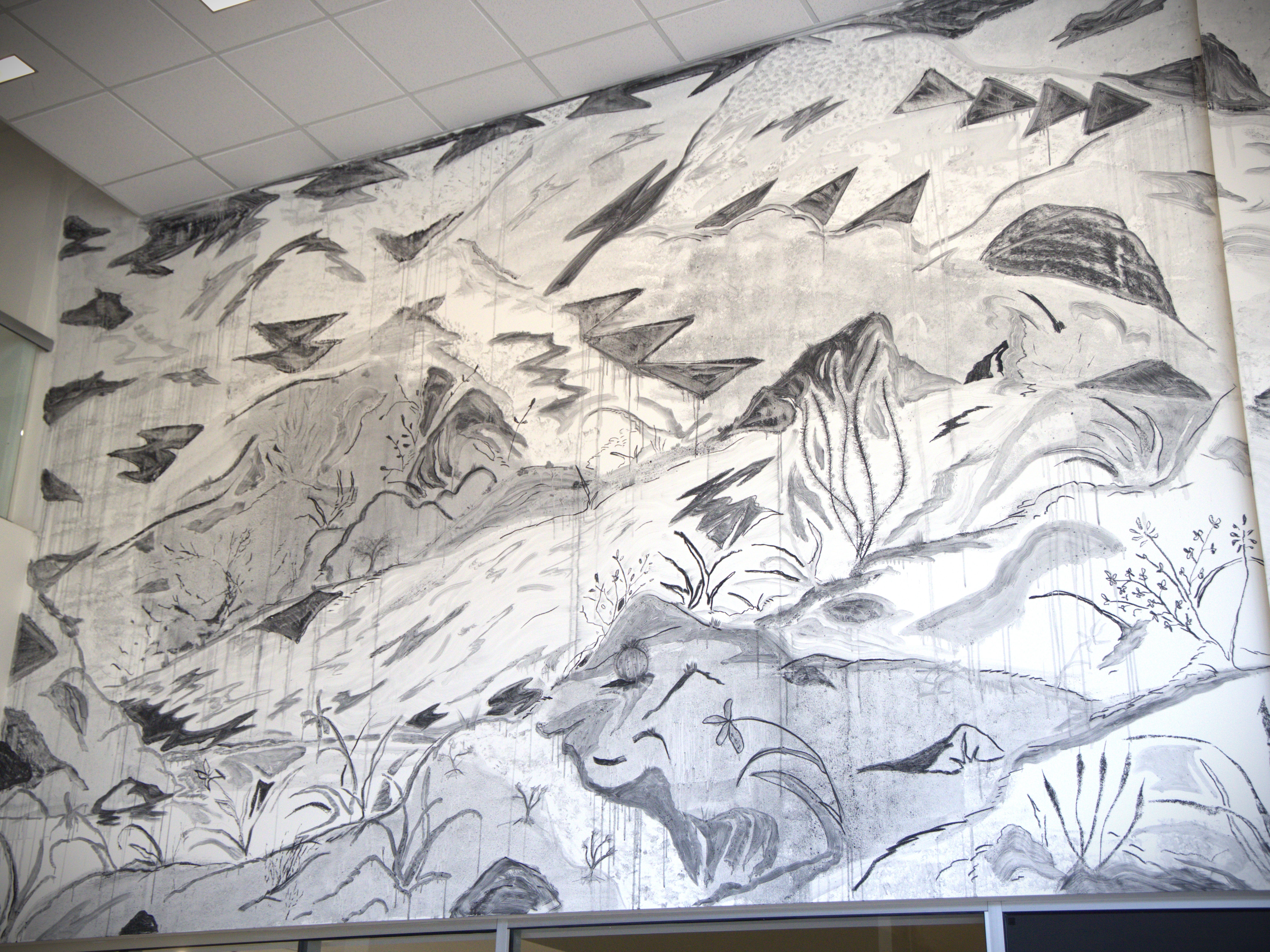 Saif Azzuz's mural — drawn in charcoal salvaged from controlled burns in Northern California — in the entryway is "a symbolic way to welcome people into the show," said co-curator Erika Mei Chua Holum.