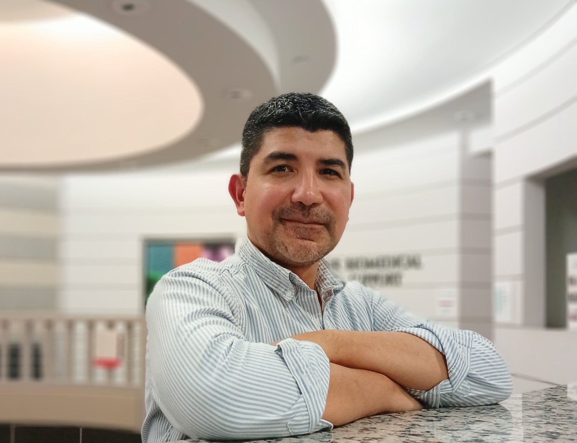 Professional photo of Bryan Medina, seated with his arms folded