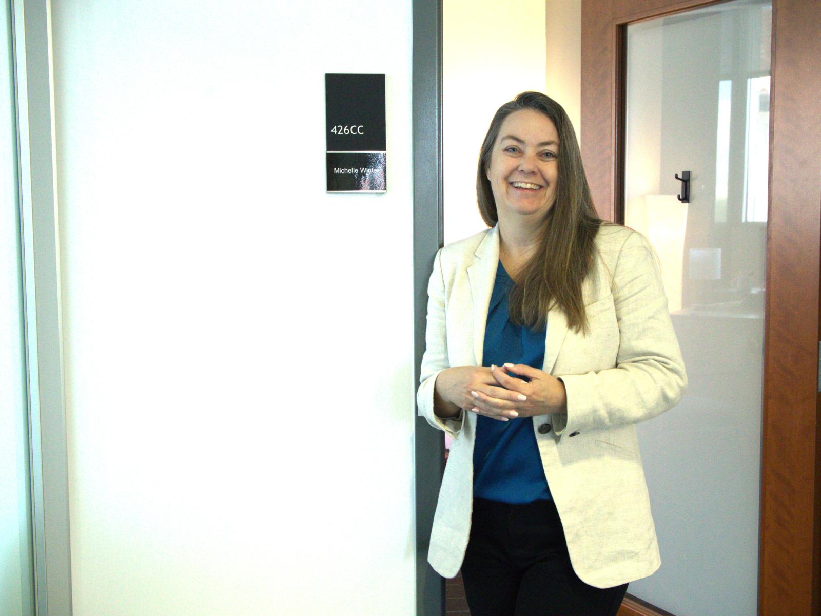 Michelle Winter, OVPR’s New Assistant Vice President for Research Core Facilities, stands outside her office smiling