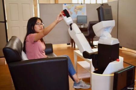 A robot hands an apple to a human